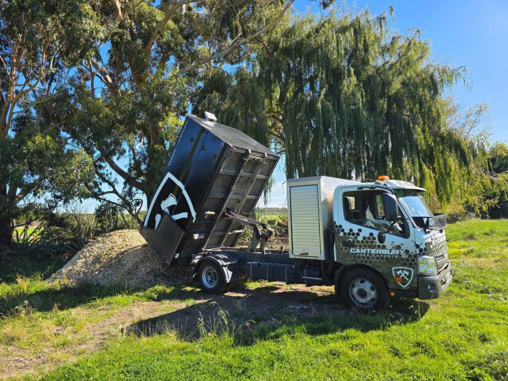 Canterbury Tree Experts truck tipping wood chip mulch from tree work in Christchurch